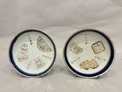 two blue and white plates with gold designs on them