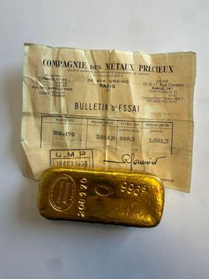 an old gold bar sitting on top of a piece of paper next to a receipt