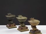 trois petits vases posés les uns à côté des autres sur une table blanche
