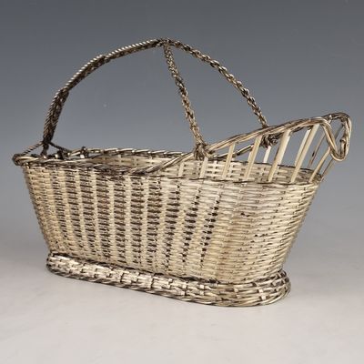 un panier en osier ancien muni d'une poignée et d'une longue anse