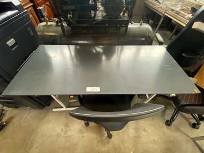 an image of a desk and chair in a warehouse