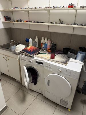 une machine à laver et un sèche-linge dans une cuisine encombrée