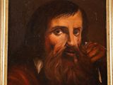 painting of a bearded man smoking a cigarette in a gold frame