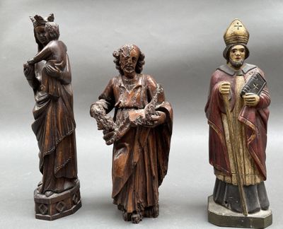 trois figurines en bois représentant des hommes portant des chapeaux et des robes