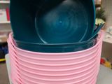 plusieurs seaux roses et bleus empilés les uns sur les autres sur une table