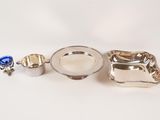 three pieces of silverware are sitting on a white surface