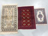 three oriental rugs on a white surface