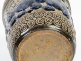 a close up of a blue and white vase on a white surface