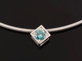 a necklace with a blue topaz stone on a black surface