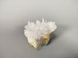 white crystals on a gray surface with a small piece of rock in the middle