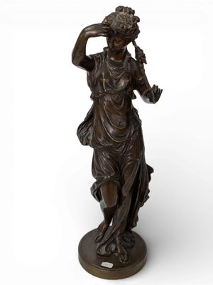 bronze statue of a woman holding a flower in her hand