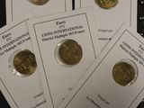 six coins are sitting on top of a binder on a table