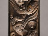 a bronze relief of a woman holding a baby in her arms