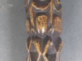 une statue en bois représentant un homme avec un oiseau sur la tête