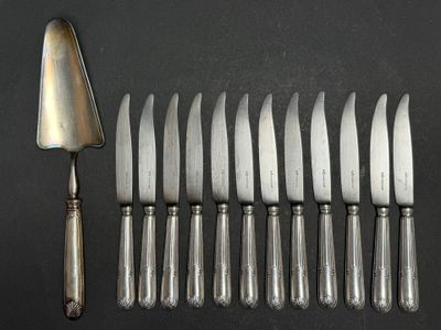 six silverplated knives and a fork on a black surface