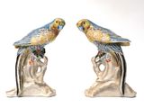 two figurines of birds sitting on a tree branch