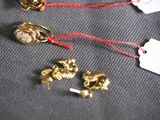 several gold jewelry items are on a black cloth with a price tag