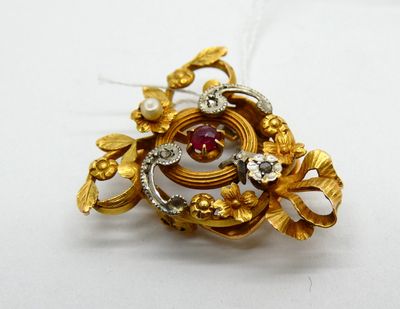 a gold brooch with a red stone in it