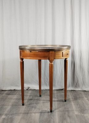 une petite table avec un plateau en marbre sur un plancher en bois