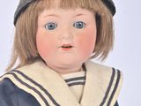 a doll that is wearing a hat and sweater
