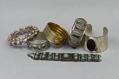 several silver and turquoise rings and bracelets on a white surface