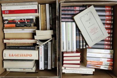 many books in a box that are stacked together