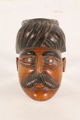a wooden head of a man with a turban on his head