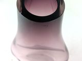 a glass vase with a black rim sitting on a white surface
