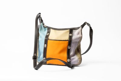 une photo d'un sac à main multicolore posé sur une surface blanche