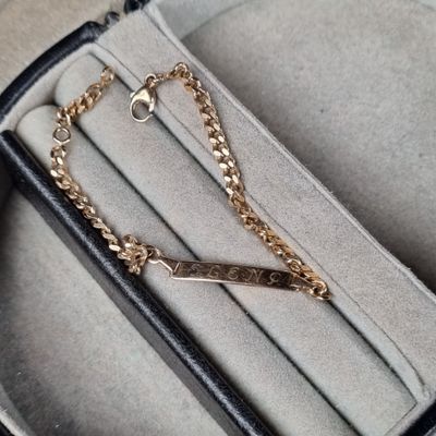 un bracelet noir et doré orné d'une chaîne dorée