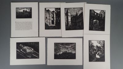 Plusieurs photographies en noir et blanc sont accrochées sur un mur gris.