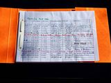 an orange folder with writing on it on a table