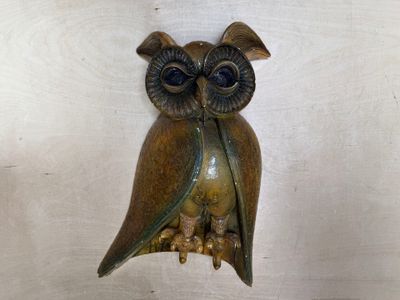 un hibou en bronze accroché au mur