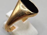 a close up of a gold ring with a black stone in it