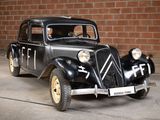 a black car parked in front of a brick wall