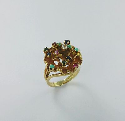 gros plan d'une bague en or avec des pierres multicolores