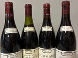 quatre bouteilles de vin sont alignées sur une table
