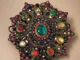 un gros plan sur une broche ornée de nombreuses pierres de différentes couleurs