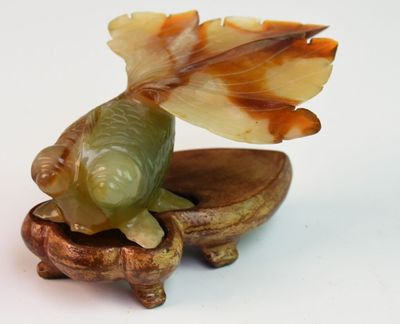 une figurine représentant un poisson et un coquillage sur un fond blanc
