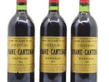 trois bouteilles de vin sont alignées sur une surface blanche
