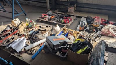 une table posée à même le sol, chargée d'objets divers et variés