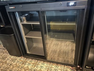 an image of a glass door refrigerator in a kitchen