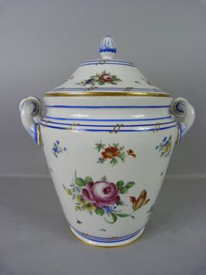 un vase blanc et bleu orné de fleurs et de papillons