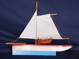 maquette en bois d'un voilier aux voiles blanches sur fond bleu