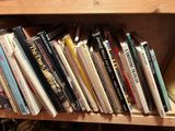 many books that are on a wooden shelf