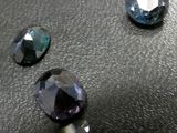 three different colored stones are sitting on a black surface