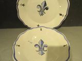 une paire d'assiettes bleues et blanches ornées de motifs de fleurs de lys