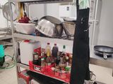 une étagère métallique avec des casseroles et des poêles dans une cuisine