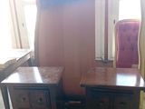 deux tables de chevet à tiroirs et une chaise dans la chambre