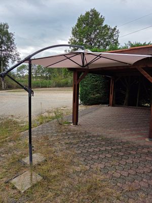 un parapluie posé au sommet d'un mât dans l'herbe